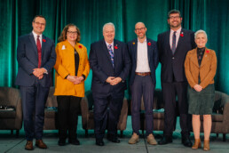 MPs on the care policy plenary pose together on stage with CCCE’s James Janeiro