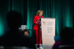 Baroness Jill Pitkeathly giving her keynote address behind the podium at the Summit