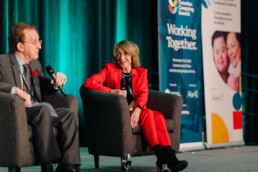 Baroness Jill Pitkeathly seated on stage with Dr. Brian Goldman
