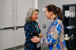 Armine Yalnizyan and Dr. Bonnie Jeanne MacDonald smiling as they greet each other