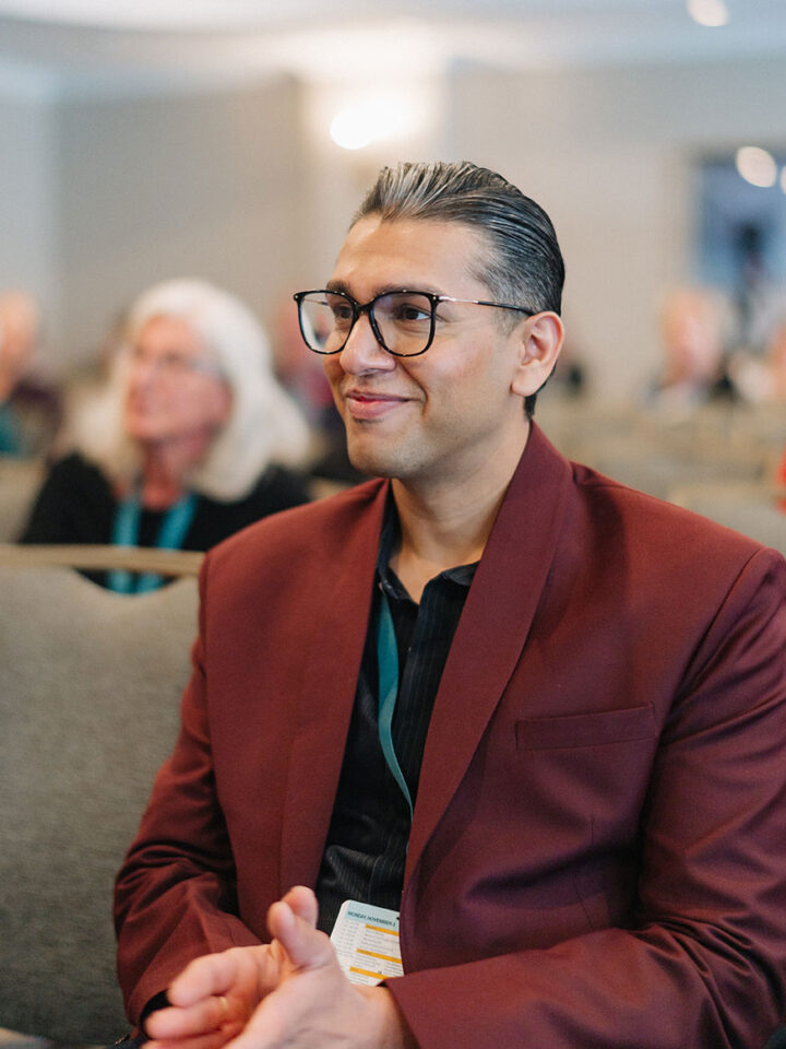 Close-up of Dr Kunal Parikh clapping while listening to a session