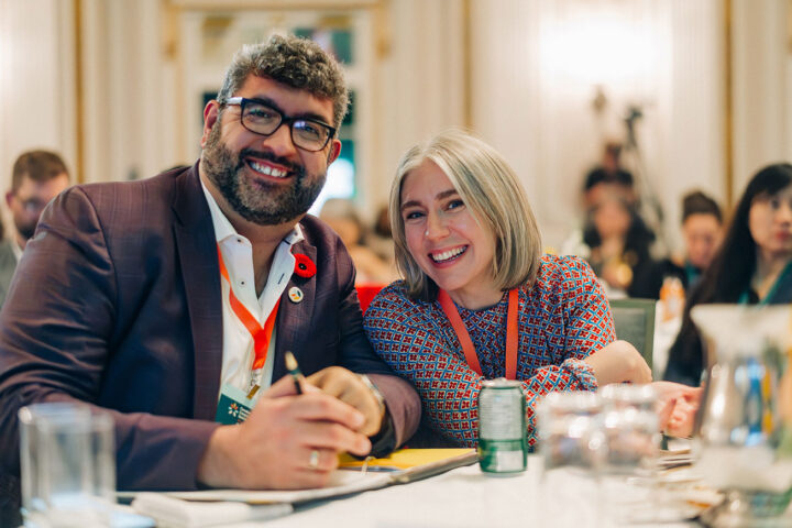 CCCE's James Janeiro and Olivia Olesinki smile while seated at a table