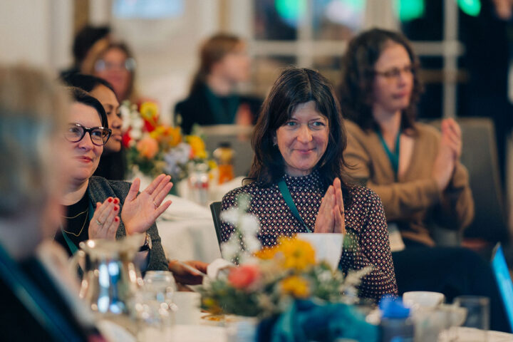Attendees applauding after a session
