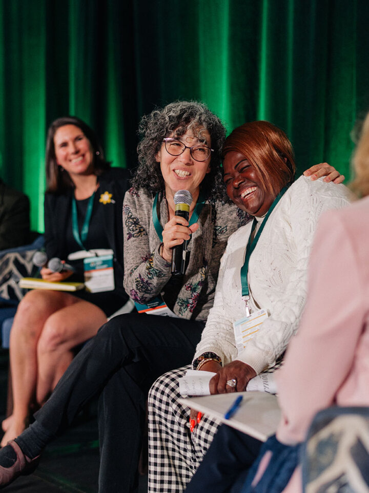 Dr. Yona Lunsky and Fredrica Pottinger share a moment of laughter and a hug on stage while presenting their idea