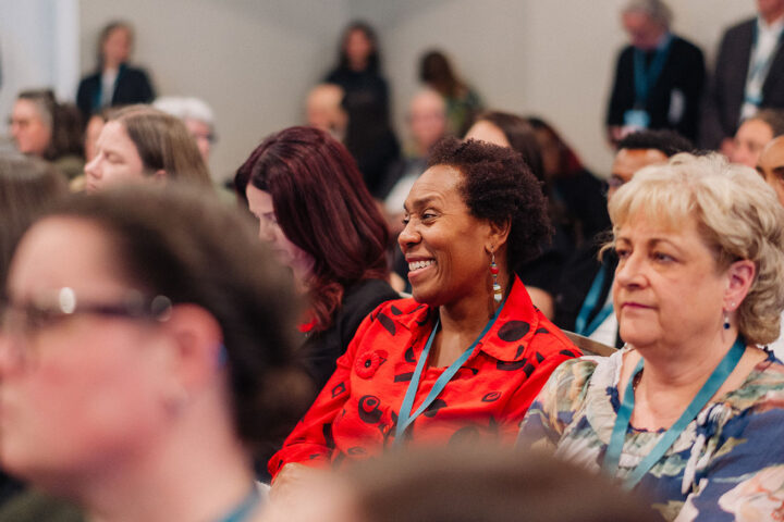 CCCE advisory council member Sherron Grant smiles while seated in the audience at a session.