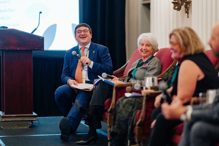 Daniel Nowoselski laughs while holding the microphone during the panel on financial security.