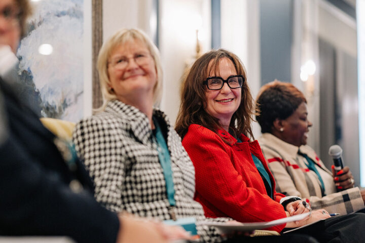 Dr. Fiona Deller smiling at the session on home care in focus, with the other panelists blurred in the background.