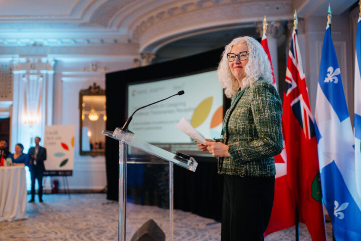 Nicole Dauz, co-host of the parliamentary reception, stands behind the podium to give welcome remarks