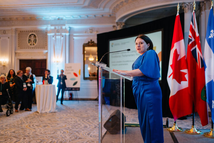 Side profile of CCCE's Liv Mendelsohn behind the podium at the parliamentary reception.