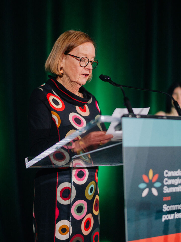Dr. Norah Keating stands on the stage at the Summit gala to introduce the Dr. Janet Fast Research Excellence Award