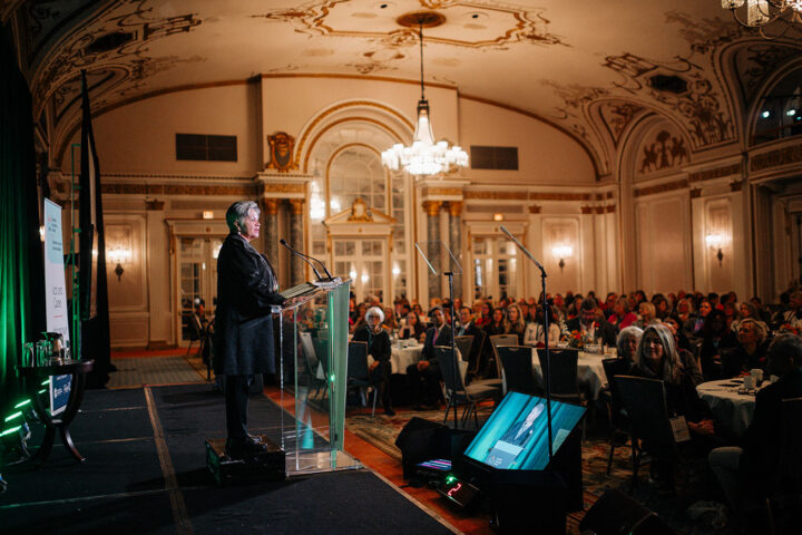 Elder Claudette Commanda gives the welcome blessing in front of a crowd of seated attendees.