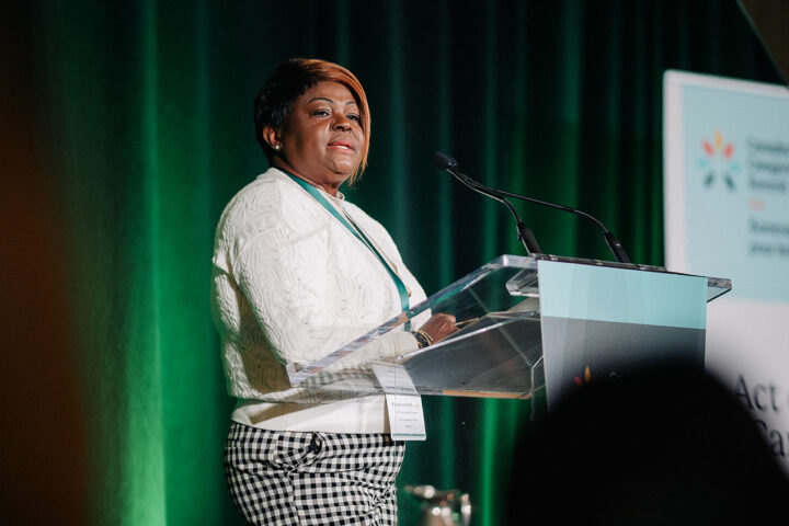 Fredrica Pottinger, a Black care provider, standing behind a podium on stage