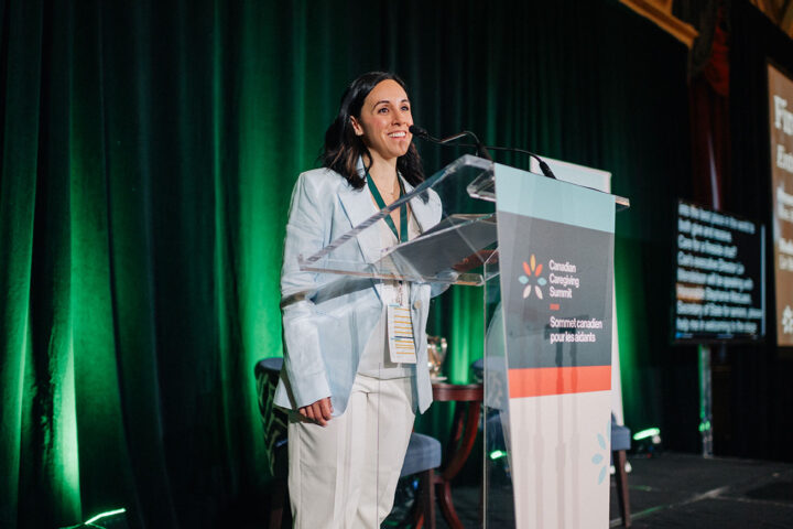 Summit host Stephanie Muskat smiles on stage