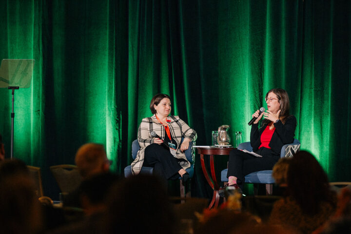 CCCE's Liv Mendelsohn seated on stage in conversation with Stephanie McLean, Secretary of State for Seniors