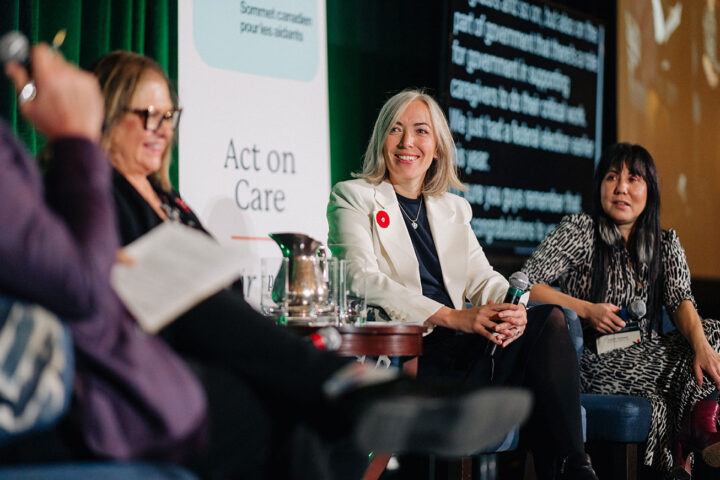 MP Leslie Church smiles during the caregiving caucus panel, with fellow panelists blurred in the background